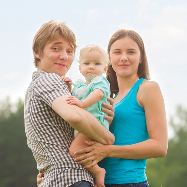 Young couple holding toddler for family photo